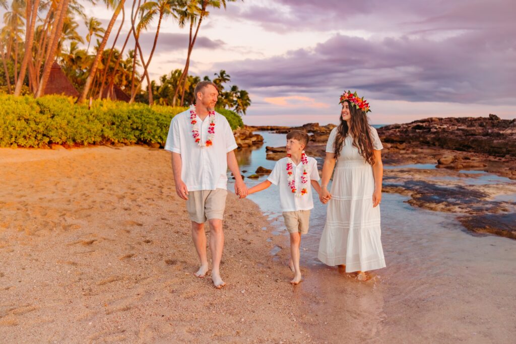 Kayla Zimmerman and her family in leis walking along a beach in Hawaii at sunset